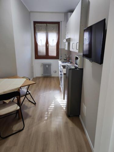 a kitchen and dining room with a table and a television at Golgi Archimede Casa in Pavia