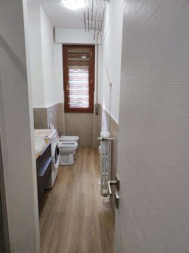 a bathroom with a toilet and a sink and a door at Golgi Archimede Casa in Pavia