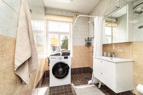 a laundry room with a washing machine in a bathroom at Peaceful studio with desk & free parking near city center in Tallinn