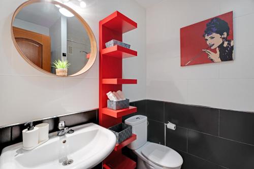 a bathroom with a sink and a mirror and a toilet at Apto Sol Paraiso Sunset View in Adeje