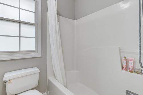 a bathroom with a toilet and a window at Park Village Home with Pond 6 Mi to Downtown Cary in Cary