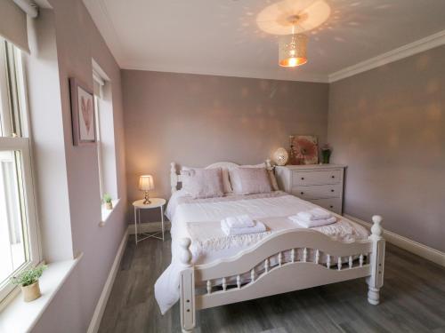 a bedroom with a white bed and a window at Shroughan in Oldtown