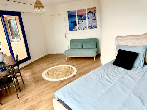 a bedroom with a bed and a couch and a table at Paris La Défense - Santorin Apartment with jacuzzi in Courbevoie