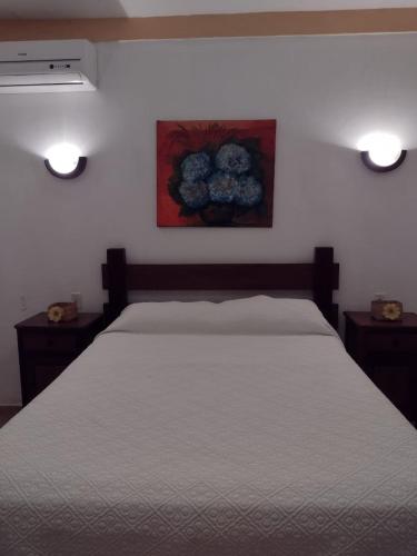 a bedroom with a bed with two lights on it at Pousada Pouso do Frade in Pirenópolis