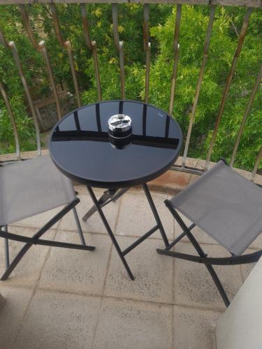 een zwarte tafel en 2 stoelen op een patio bij Balkan Aparts in Hisarya