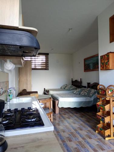 a kitchen with a stove and a bedroom with a bed at Finca Orion 203 in Guarne