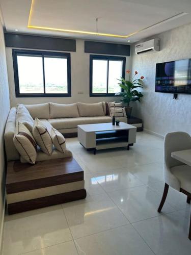 a living room with a couch and a coffee table at Nour Beach Cabo in Martil