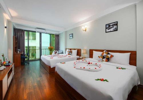 a hotel room with two beds and a balcony at Family Suite Hotel in Hanoi