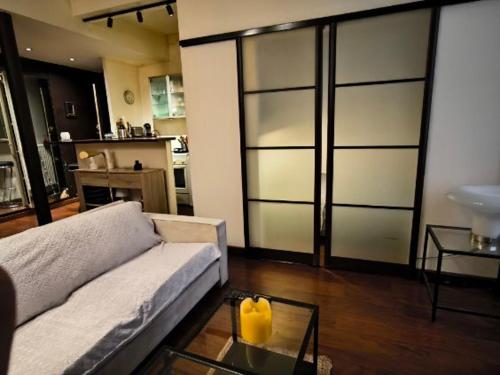 un salon avec un canapé et une table en verre dans l'établissement Jardin Montoulieu, à Toulouse