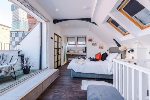 a bedroom with a bed and a large window at Incredible 3Bed Townhouse, Rooftop Patio, Sleeps 6 in Manchester
