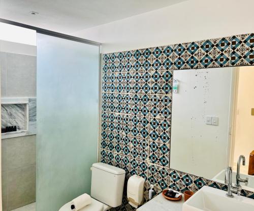 uma casa de banho com um WC e um espelho. em Angá Beach Hotel em São Miguel dos Milagres