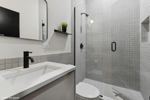 une salle de bain blanche avec un lavabo et des toilettes dans l'établissement Logan Square SRO Hotel, à Chicago