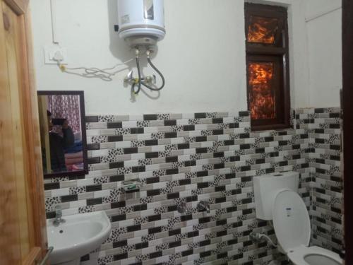 a bathroom with two toilets and a sink and a mirror at Sukham Nest's Limewood Homestay in Rishop