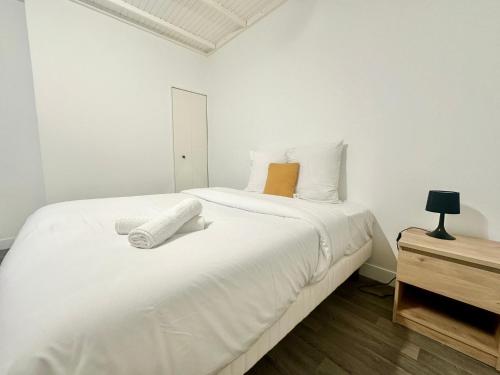 un lit blanc avec deux serviettes dessus dans l'établissement Le Puits de Lumière, spacieux et atypique, à Limoges