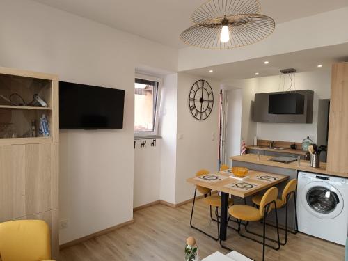 une cuisine avec une table et des chaises dans une pièce dans l'établissement aux nids douillets mayetois 