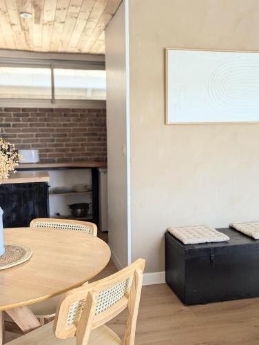 a dining room with a table and a couch at Duplex Lomy vue sur le port avec Sauna-balneo-5mn plage in Pléneuf-Val-André