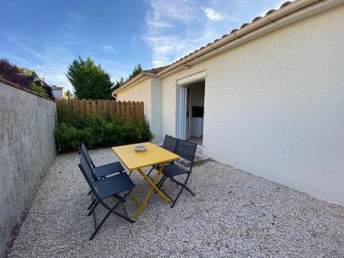 une table et des chaises jaunes devant un bâtiment dans l'établissement Maisons Martigny B - Proche Futuroscope et Aquascope, à Chasseneuil-du-Poitou