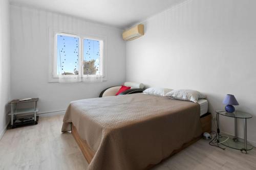 une chambre blanche avec un lit et une fenêtre dans l'établissement Appart proche mer 5 min du centre, à Saint-Raphaël