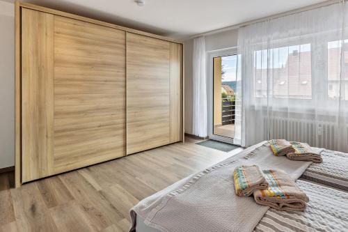 a bedroom with a bed and a large wooden cabinet at Ferienwohnung Am Alten Brunnen in Gaienhofen