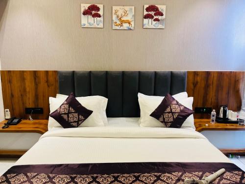 a large bed with a black headboard in a room at Hotel Royal Empire in Gandhinagar