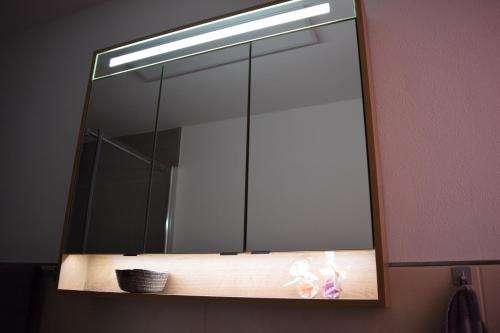 a mirror on a wall above a bathroom sink at Haus Tala in Marquartstein
