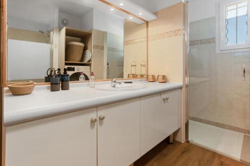 une salle de bain blanche avec un lavabo et une douche dans l'établissement Appt 120m2 Vue mer 2 min du centre, à Saint-Raphaël