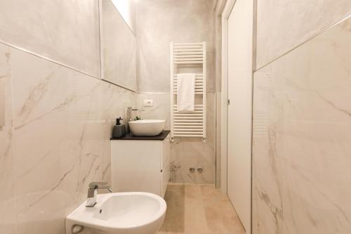 a white bathroom with a sink and a toilet at MagicFlo Santa Croce Appartamento in Florence