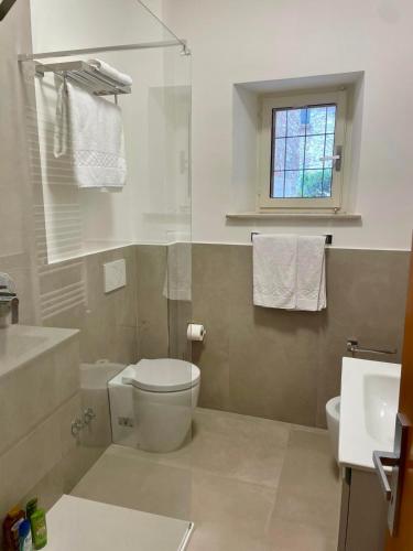 a bathroom with a toilet and a sink and a window at Le Volte di via Portica - Deluxe Apartments Italia in Assisi