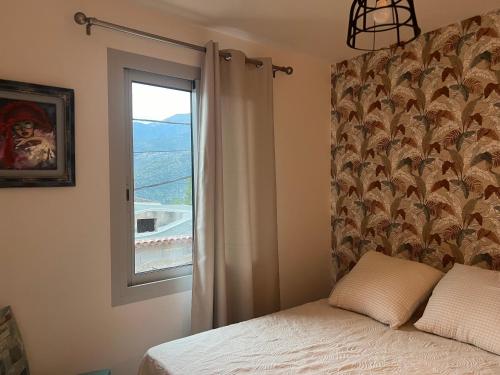 une chambre avec un lit et une fenêtre dans l'établissement La place du Four Communal, à Breil-sur-Roya