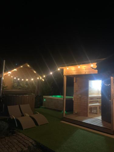 a small wooden shed with a pool at night at Casa Gorjeana Complex Agroturistic in Peştişani