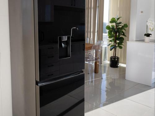 cocina con nevera negra y maceta en St Tropez Beachfront 101, en Strand