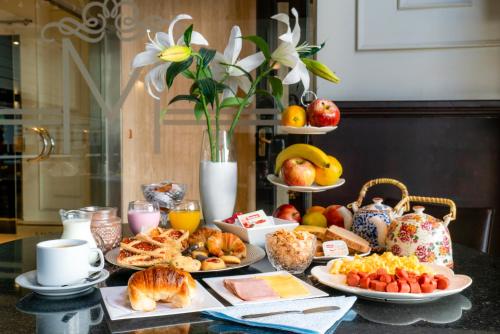 a table topped with plates of food and pastries at Gran Hotel Miglierina in Mar del Plata