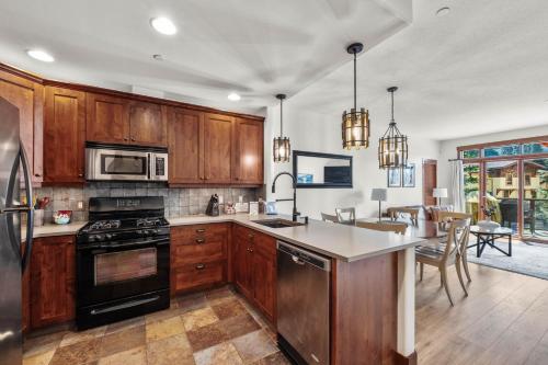 a kitchen with wooden cabinets and a stove top oven at Trappers Landing #30 in Sun Peaks
