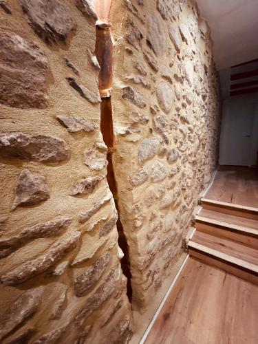 a room with a stone wall and a wooden floor at Can Pedra Seca in Camprodon
