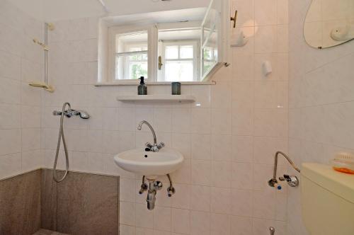 a white bathroom with a sink and a shower at Ambrózia Villa in Balatonfüred