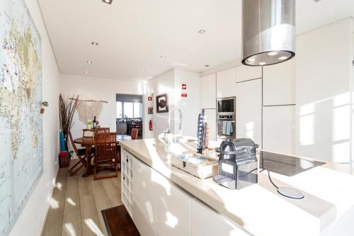a kitchen with white appliances and a dining room at Apartment Casa Verena in Oeiras