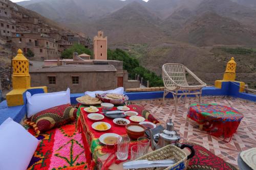 einen Tisch mit Essen auf einem Balkon mit Bergblick in der Unterkunft Dar Bejmate - Chez Hassan in Tacheddirt