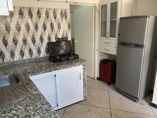 a kitchen with a refrigerator and a sink at Paddle Out Morocco in Tamraght Ouzdar