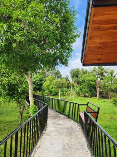 a fence with a bench next to a park at Hindad Nature Resort in Ban Ni Khu Hu