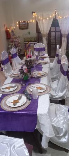una mesa de color púrpura y blanco con platos y copas de vino en Hostal amancay, en Cafayate