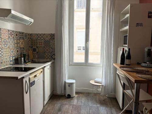 une petite cuisine avec un évier et une fenêtre dans l'établissement Studio saint Victor proche Vieux port, à Marseille