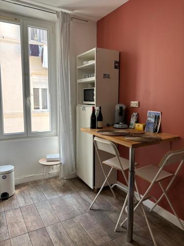 une cuisine avec une table avec des chaises et un réfrigérateur dans l'établissement Studio saint Victor proche Vieux port, à Marseille