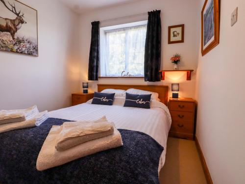 a bedroom with a bed with blue pillows and a window at The View in Faversham