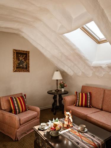 a living room with two couches and a table at Monasterio, A Belmond Hotel, Cusco in Cusco