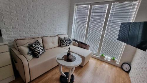 a living room with a couch and a table at Апарамент за гости Романс Марин in Sunny Beach