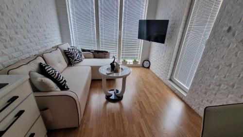 a living room with a couch and a table at Апарамент за гости Романс Марин in Sunny Beach