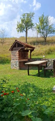 a picnic table and a bench in a field at Vila Ami in Kremna