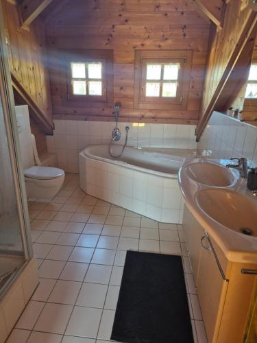 une salle de bain avec une baignoire, un lavabo et des toilettes dans l'établissement Großes gemütliches Chalet im Steigerwald nähe Bamberg, à Lisberg
