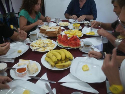a group of people sitting around a table with food at Dilshan Guest in Polonnaruwa