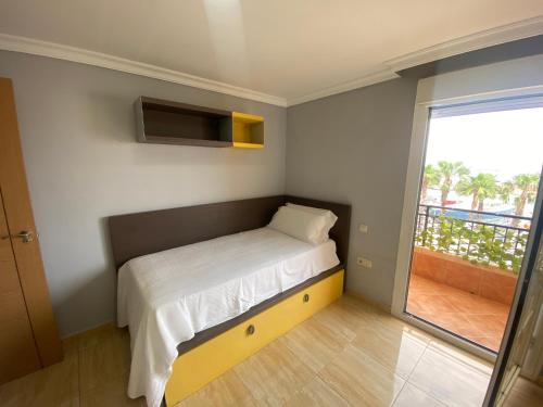a small bedroom with a bed and a balcony at Marina Vista Puerto in Ceuta